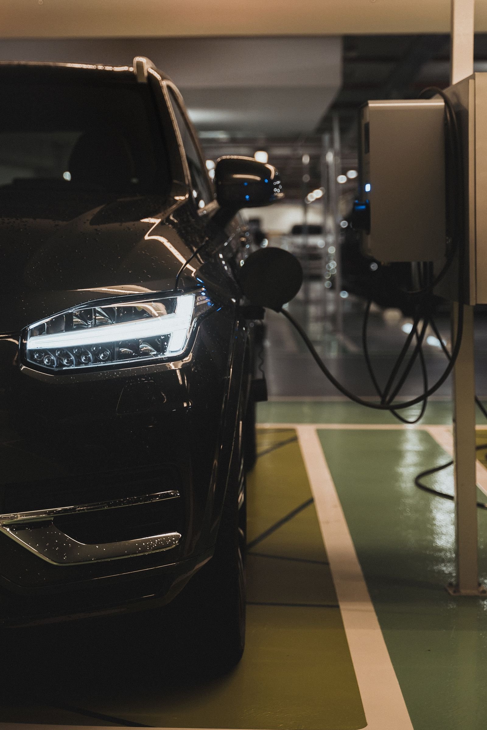 Électricité à Paris et en Île-de-France Véhicule électrique noir en charge sur une borne – Électricité Maison dans le Val-de-Marne (94)