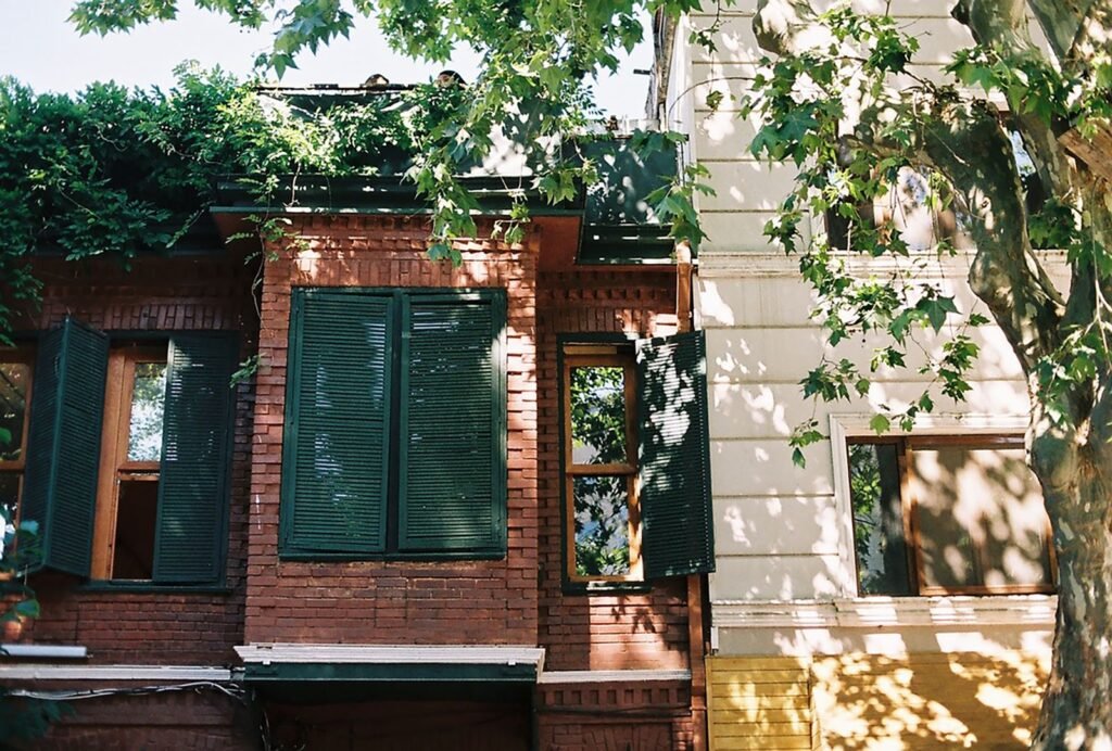 Maison en brique avec volets en bois verts