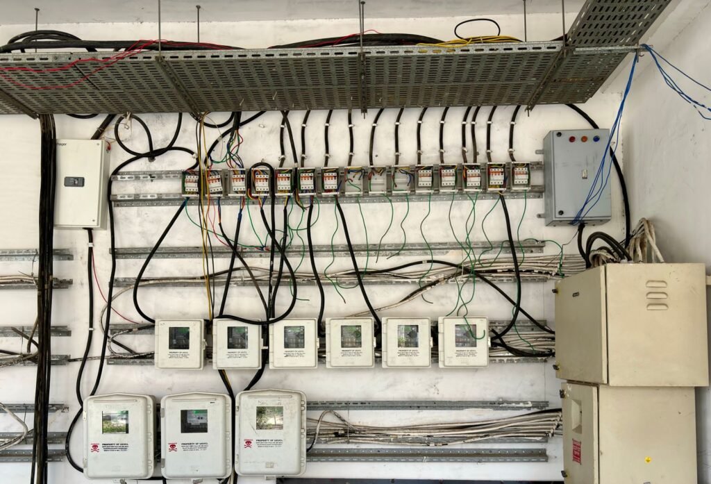 Tableau électrique ouvert avec câbles et interrupteurs visibles