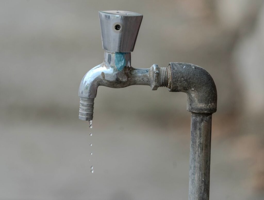 Gros plan sur un robinet extérieur qui goutte