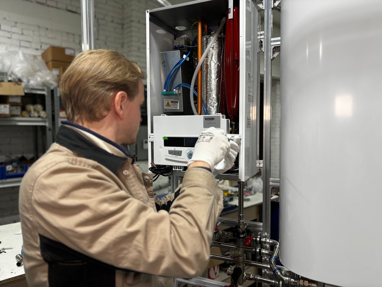 Technicien réparant un système de chauffage dans un atelier – Installation de Pompe à Chaleur dans les Yvelines (78)