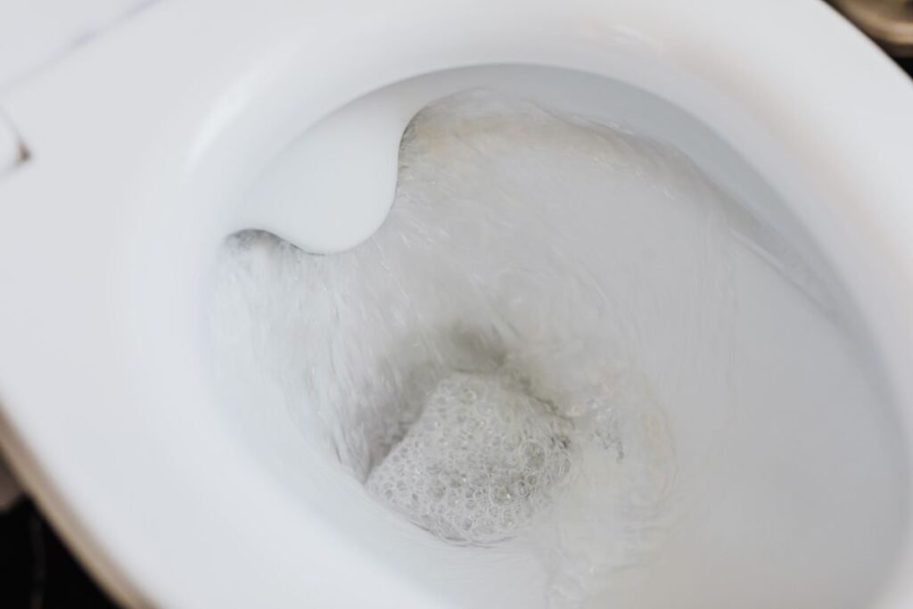 raccordement wc, chasse d'eau dans une cuvette blanche