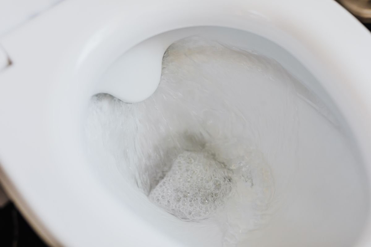 Chasse d'eau dans une cuvette de toilette blanche – Travaux de Plomberie dans les Yvelines (78)
