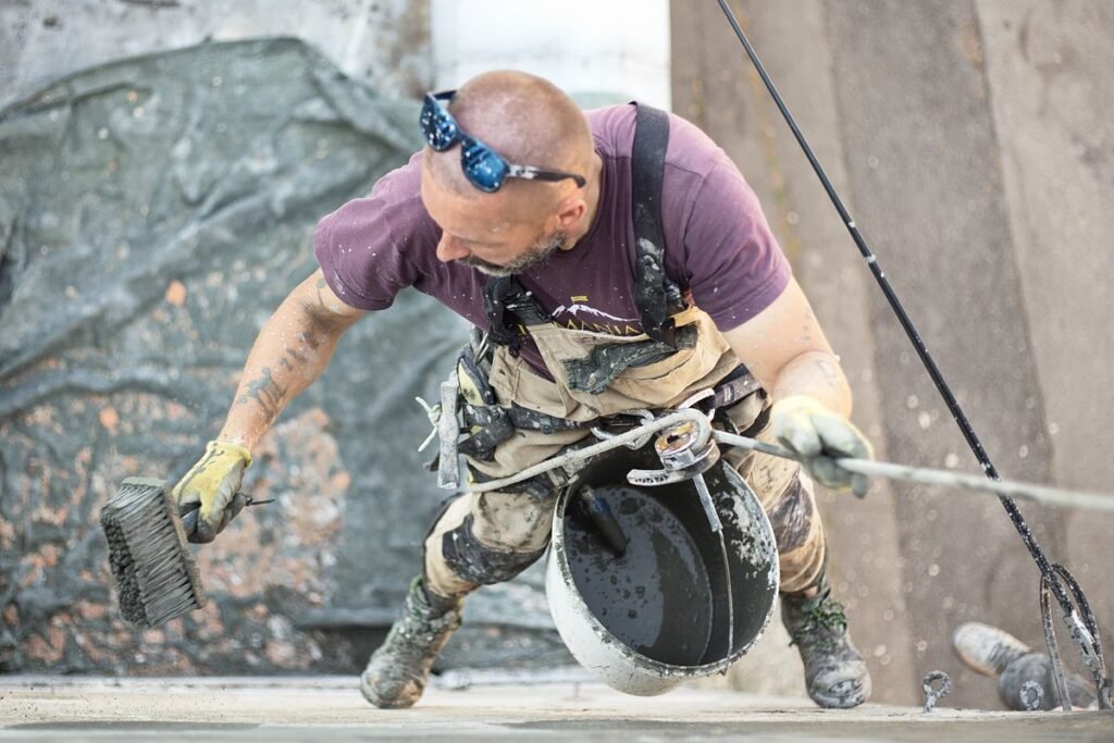Ouvrier appliquant un enduit décoratif au couteau sur un mur