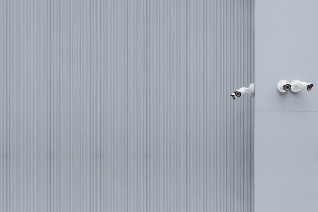 Caméras de vidéosurveillance installées sur un mur gris